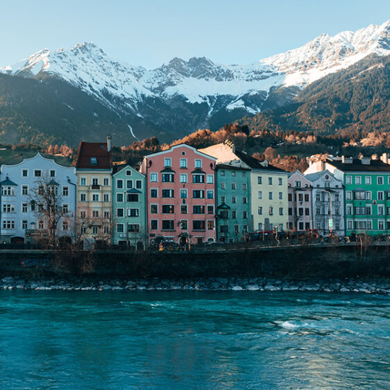 Bunte Häuser am Flussufer, Berge dahinter