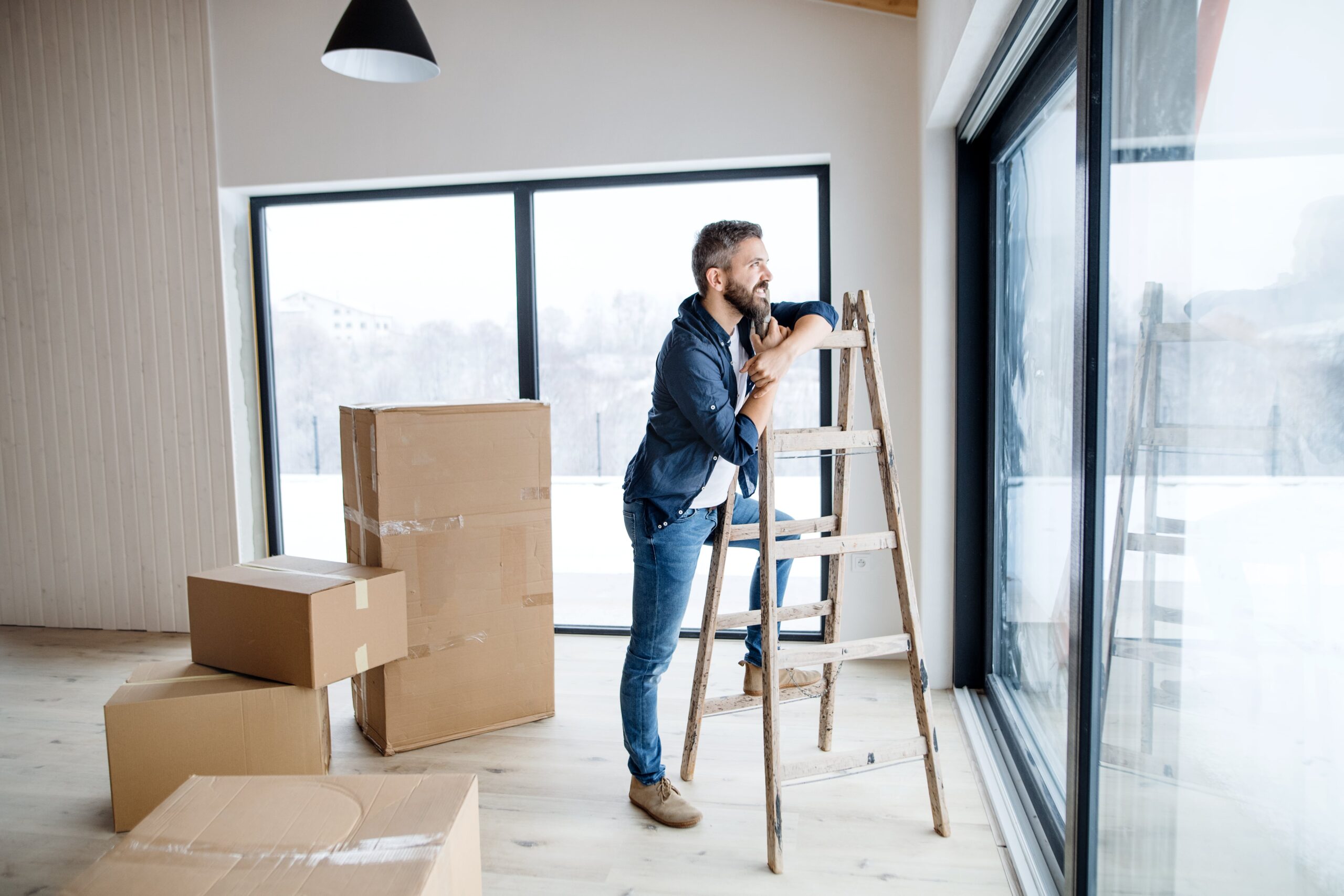 a-mature-man-with-cardboard-boxes-standing-by-a-wi-2023-11-27-04-57-51-utc-min